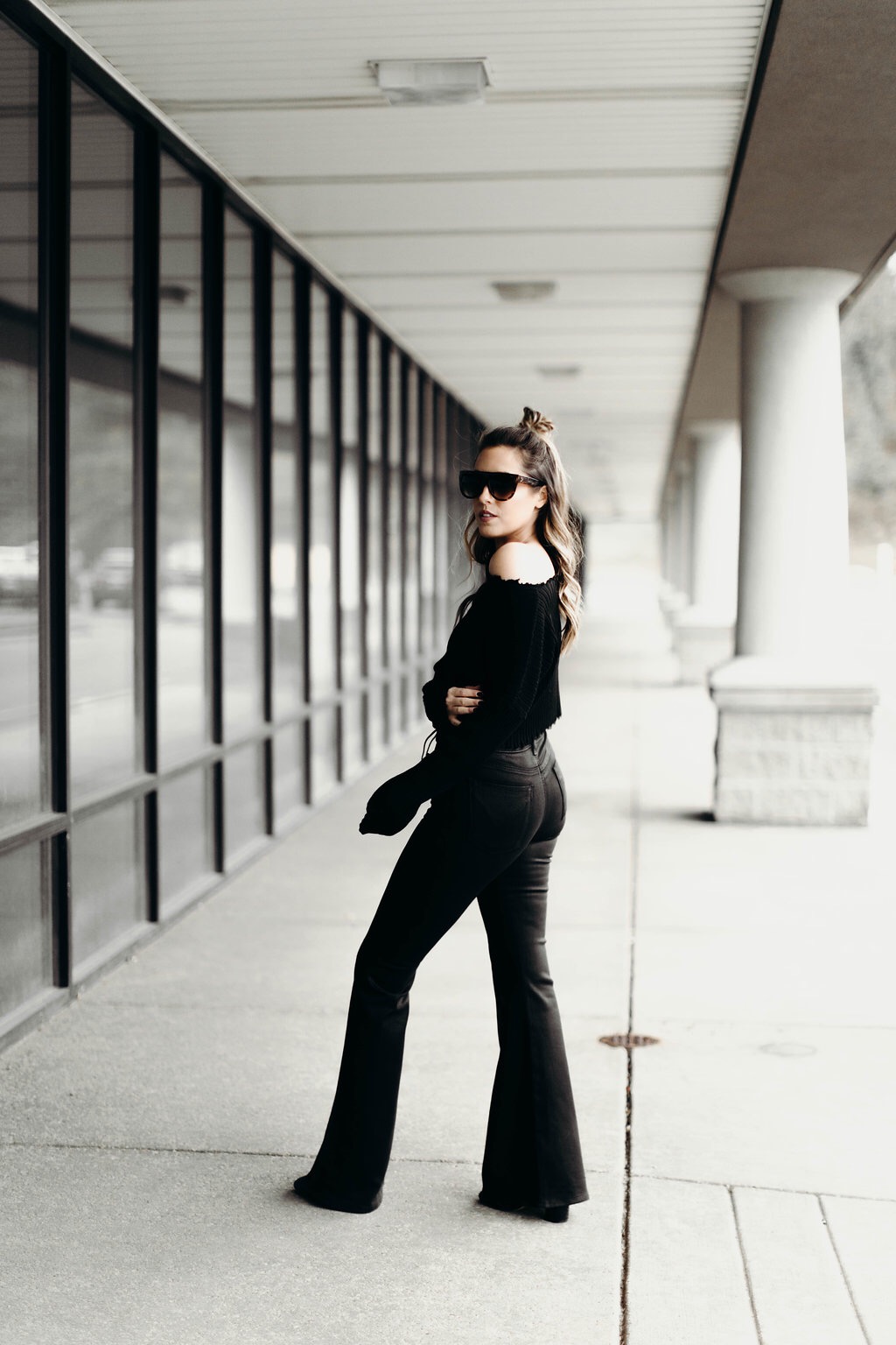 Jenna Boron, creator of life and personal style blog, Balance & Chaos, wears Hudson Bullocks High Rise Flare jeans, AKIRA raw hem sweater, shield sunglasses